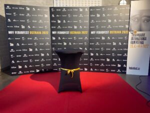 PR stěna s logy partnerů a nápisem festivalu