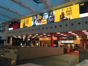 Reklamní plocha v obchodním centru nad foodcourtem s grafikou festivalu