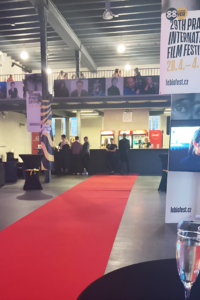 Fotka z prostředí festivalu s grafickými výstupy v pozadí
